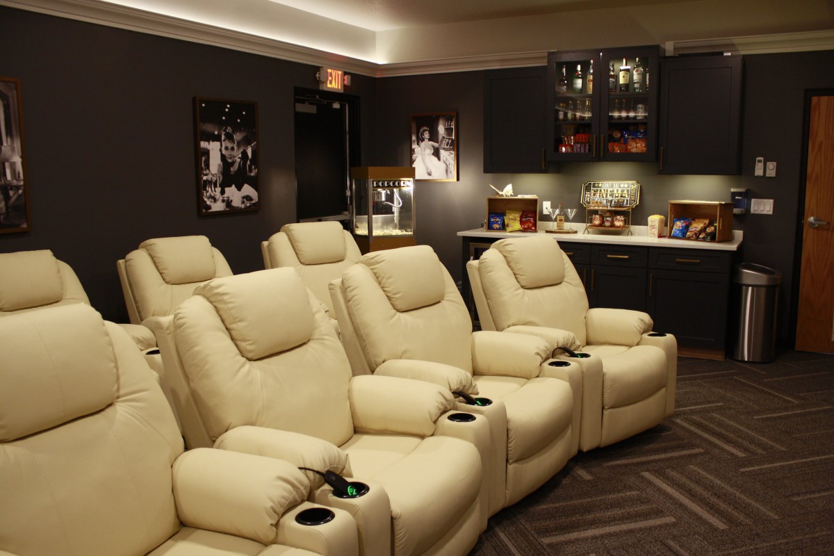 A luxurious home theater setup with comfortable recliner chairs and ambient lighting.