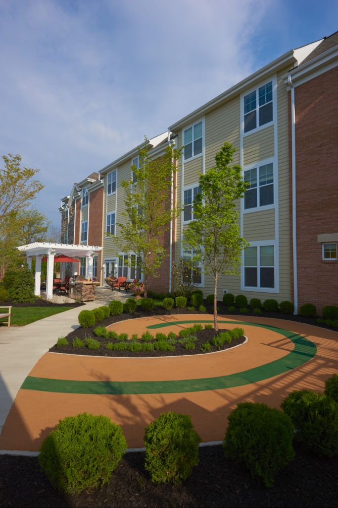 An exterior view of a modern building with a landscaped garden and pathway.
