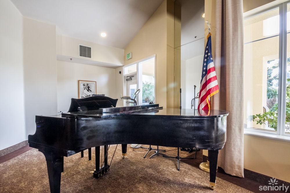 A grand piano in a room with an American flag and soft lighting.