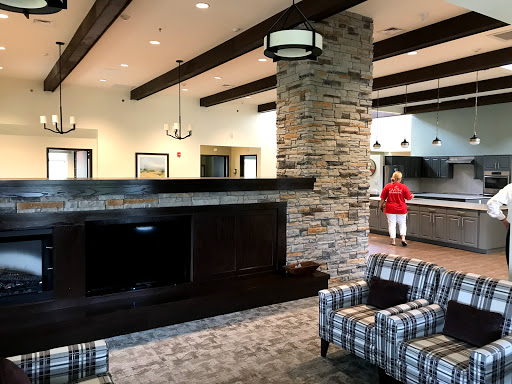 A spacious and modern lobby area featuring comfortable seating, a stone fireplace, and stylish lighting.
