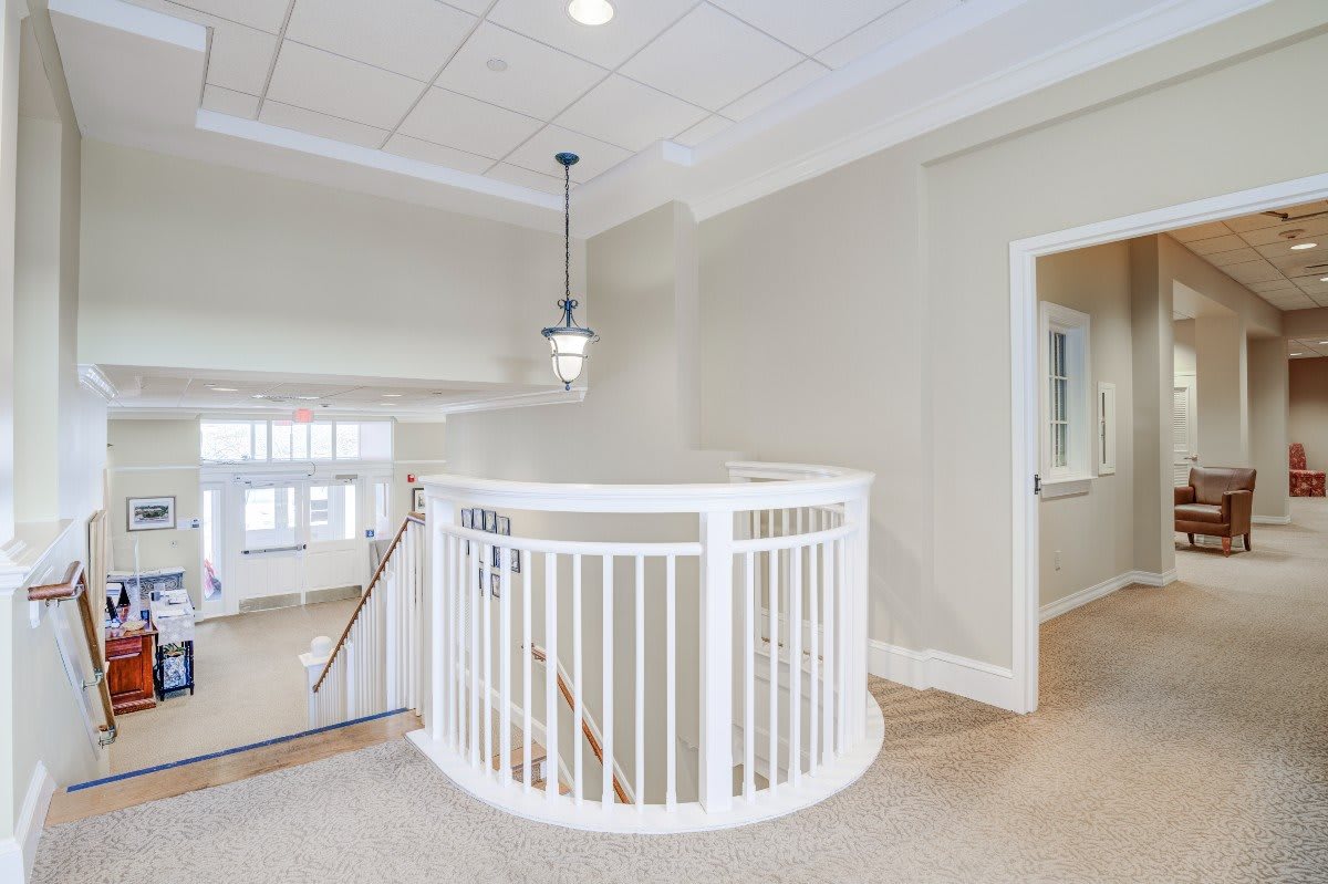 A modern interior featuring a white circular staircase with railing and ceiling light.