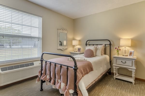 A cozy bedroom with a neatly made bed, soft lighting, and elegant decor.