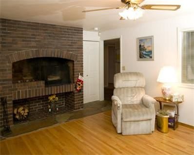 A cozy living room featuring a fireplace, armchair, and warm lighting.