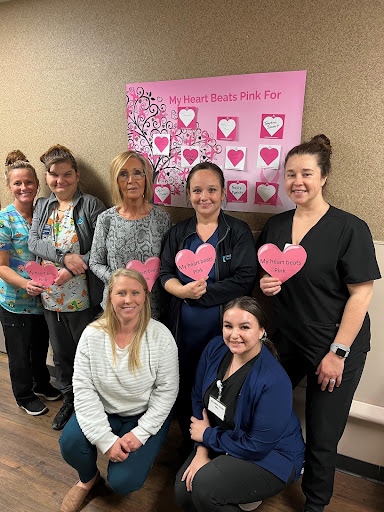 Healthcare team celebrating with heart-shaped props.