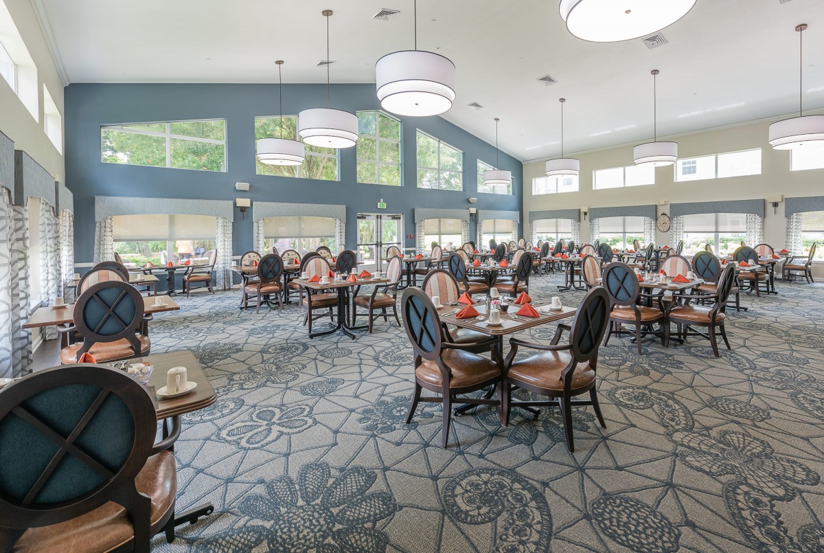 A spacious dining area with modern decor, featuring large windows and elegant lighting.