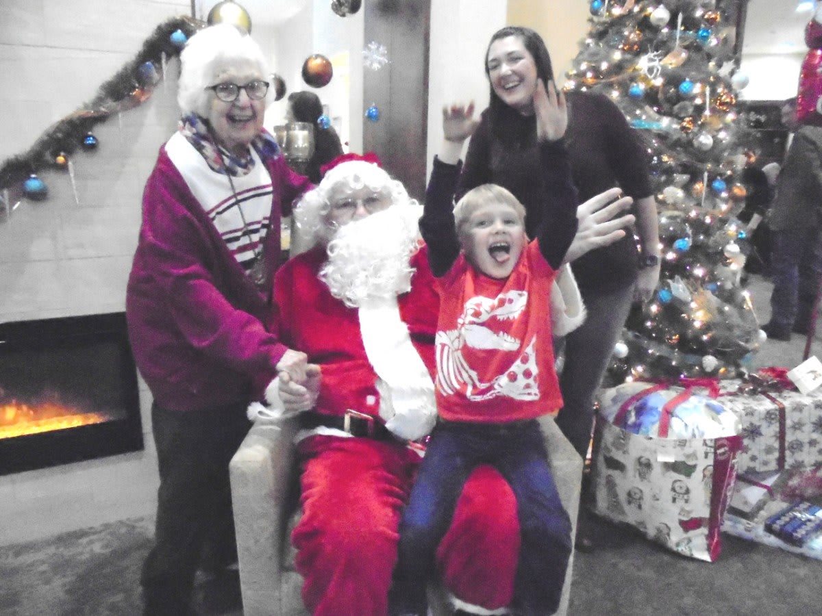 A joyful family poses with Santa Claus during a festive Christmas celebration.