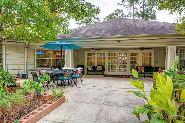 A cozy outdoor patio area with seating and a large umbrella.