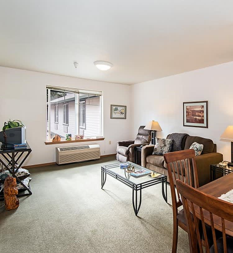 A cozy living room with comfortable seating, a wooden table, and decorative elements.