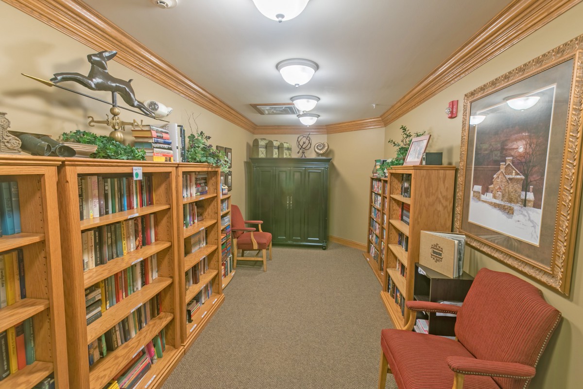 A cozy library space featuring bookshelves lined with books and a comfortable reading area.