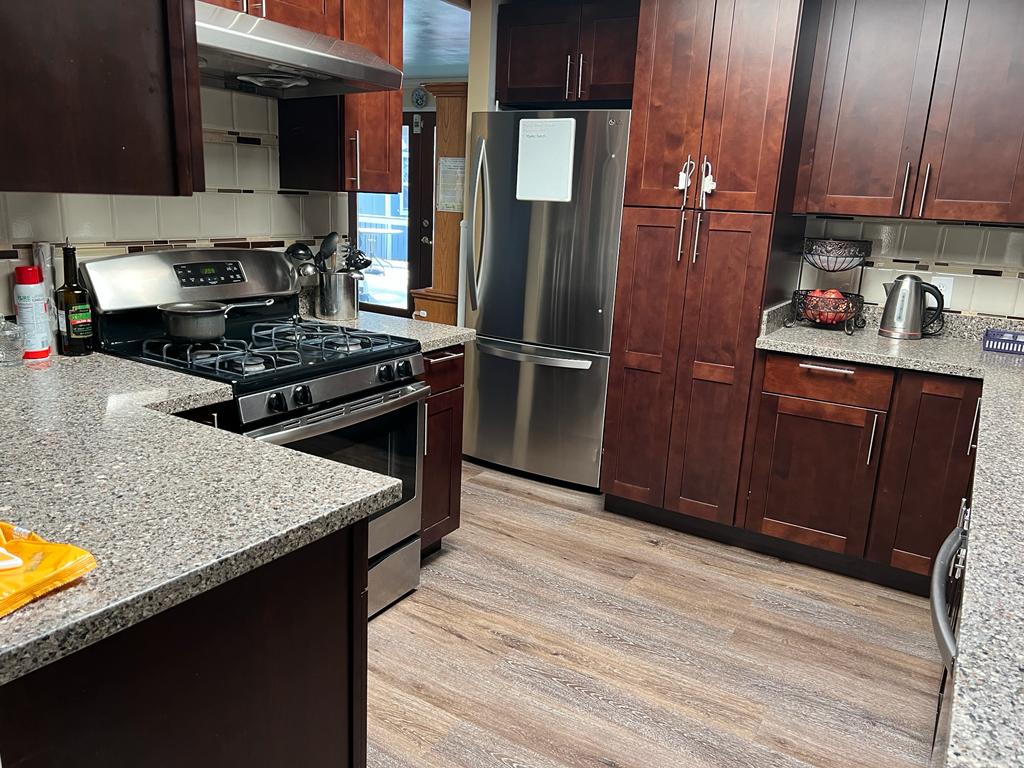 Modern kitchen interior with wooden cabinets and stainless steel appliances.