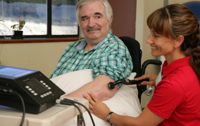 An elderly man having his blood pressure checked by a healthcare professional.