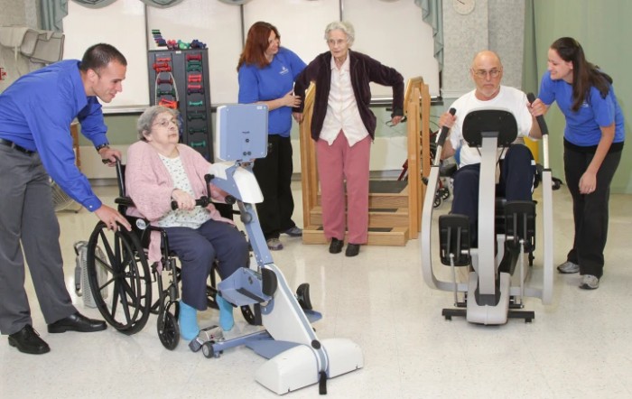 Elderly individuals participating in physical therapy exercises at a care facility.