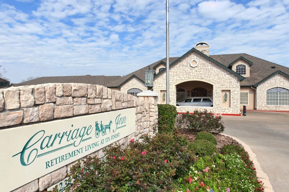 The entrance of a retirement living facility with well-maintained landscaping and clear signage.