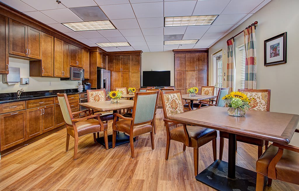 A cozy dining area with wooden furniture and sunflowers on the tables.