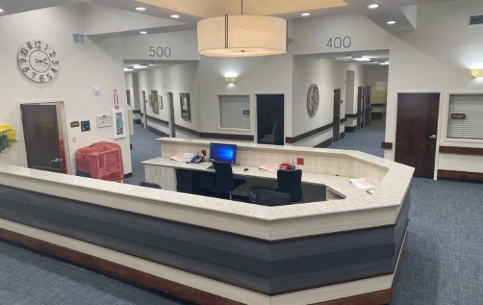 A quiet hospital reception area with empty desks and long corridors.