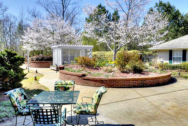 A scenic garden patio with blossoming trees and outdoor seating.