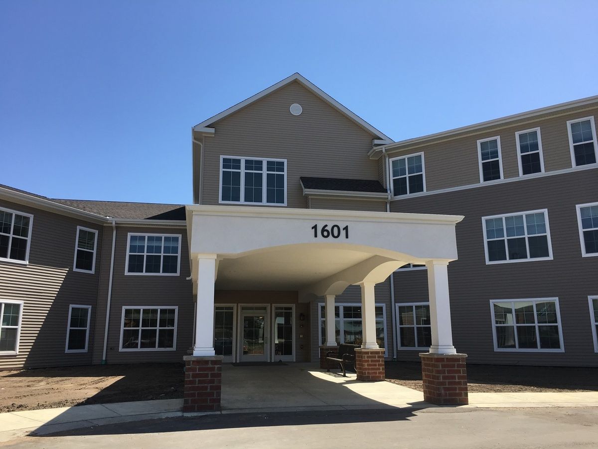 A modern building entrance with a covered entryway and large windows.