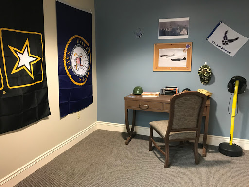 A military-themed office space featuring insignia and a modest desk setup.