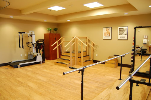 A tranquil rehabilitation room equipped for physical therapy with stairs and ballet bars.