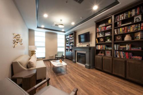A modern living room with a cozy fireplace and built-in bookshelves.