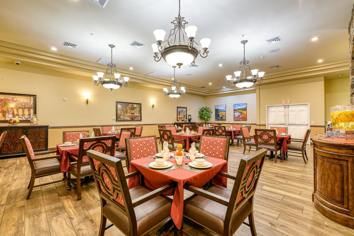 An elegant dining room with neatly arranged tables and chandeliers.