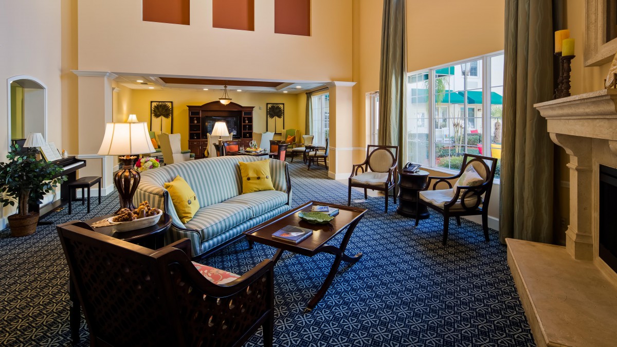A cozy living room with comfortable seating, elegant furniture, and large windows.