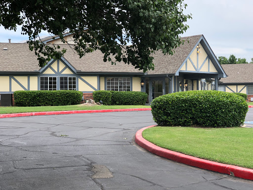 A charming building surrounded by well-maintained landscaping and a curved driveway.