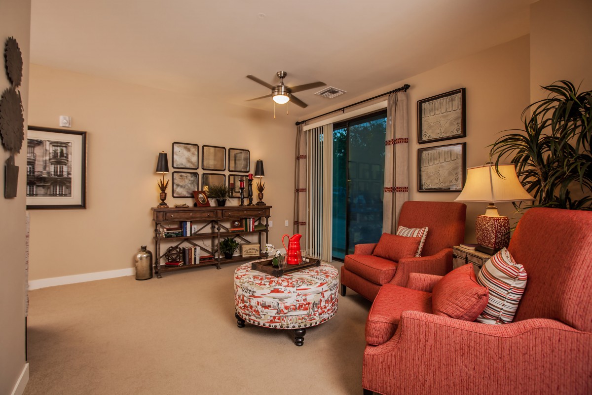 A cozy living room with red armchairs, a patterned coffee table, and elegant decor.
