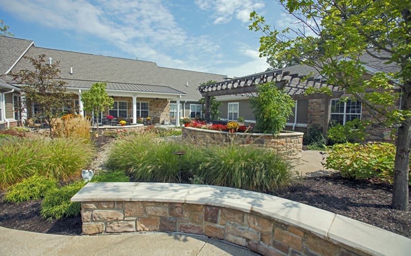 A beautiful outdoor garden with lush greenery and a building in the background.