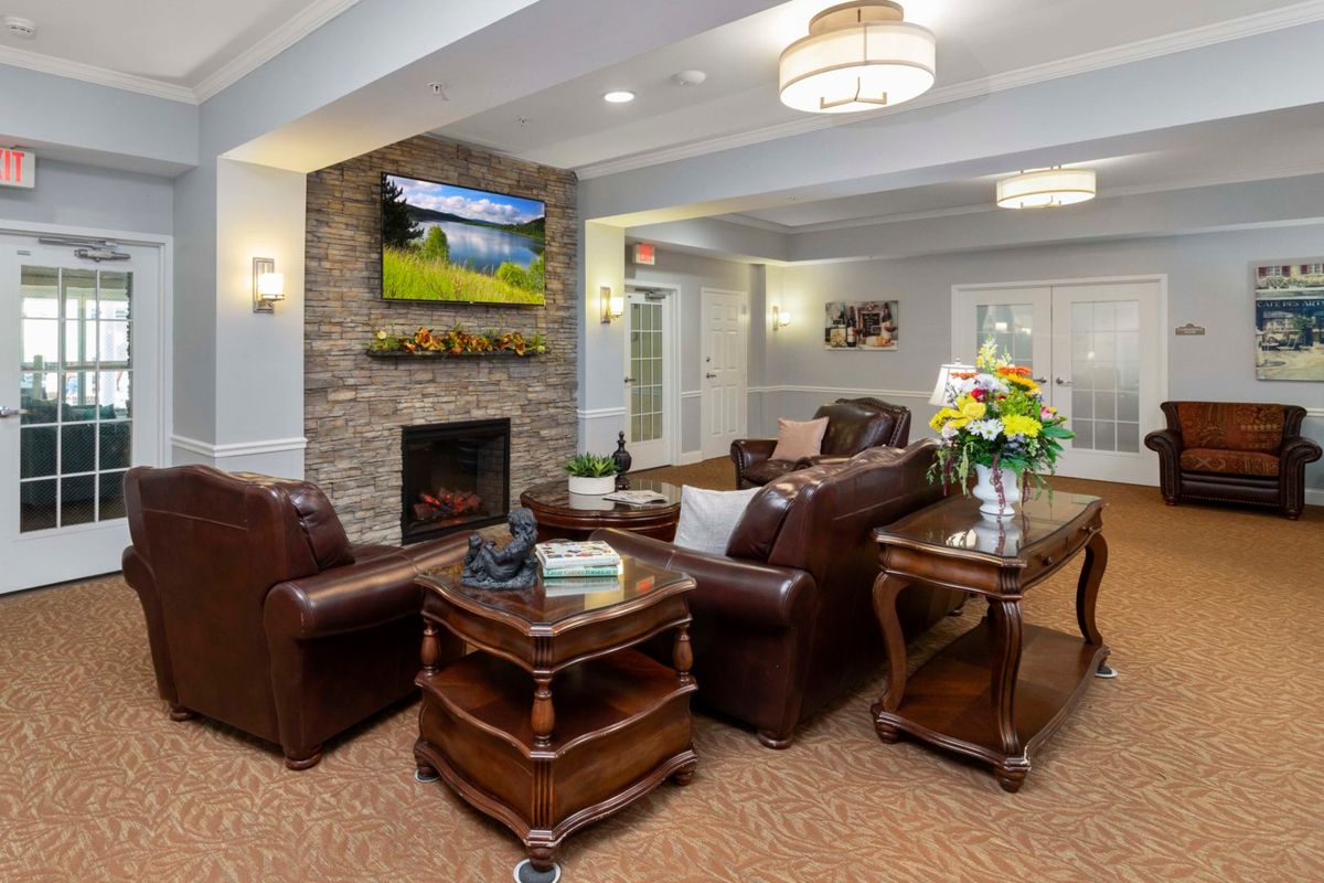 A cozy living room with leather sofas and a fireplace, adorned with elegant decor.