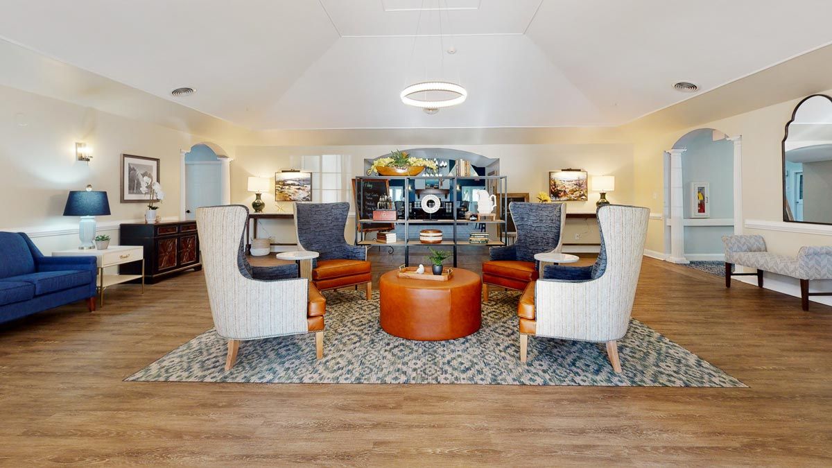 A modern living room with a cozy seating area featuring stylish armchairs and a central coffee table, complemented by elegant decor and lighting.