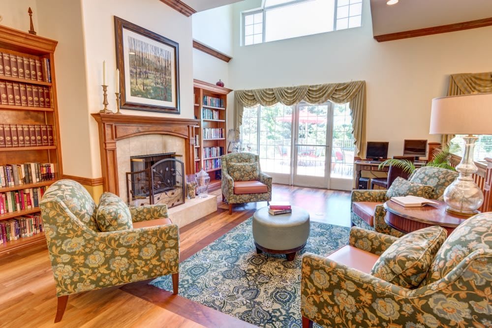 A cozy living room with a fireplace, elegant furniture, and a large window providing natural light.