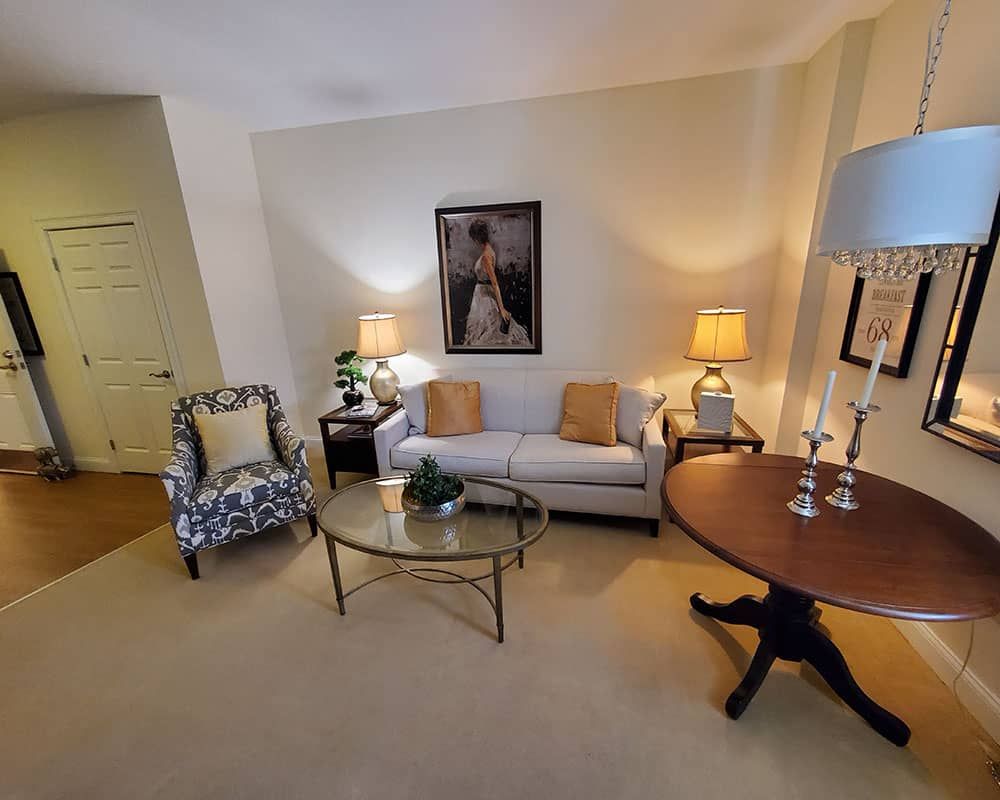 A cozy living room with a sofa, armchair, and stylish decor.