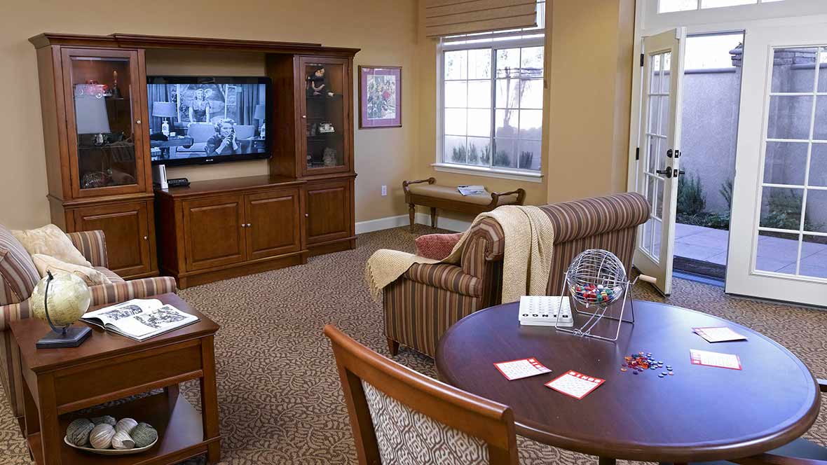 A cozy living room with a television, sofa, and table.
