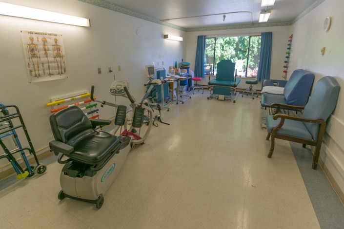 A view of a medical clinic room with chairs and equipment.