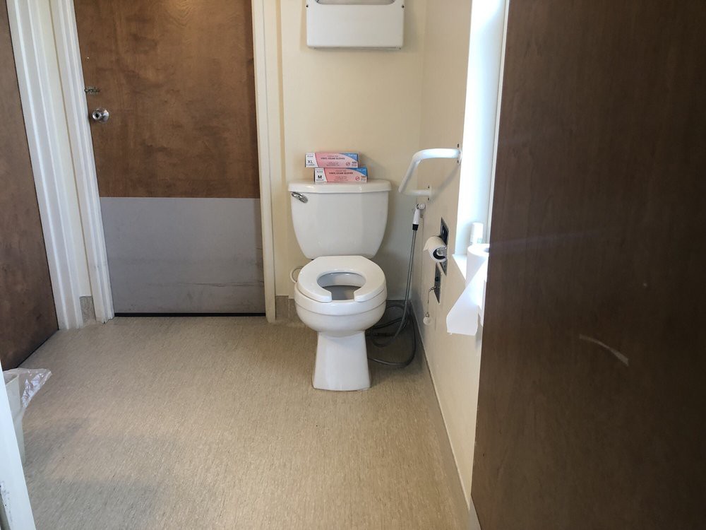 A clean bathroom with a toilet and paper roll holder.