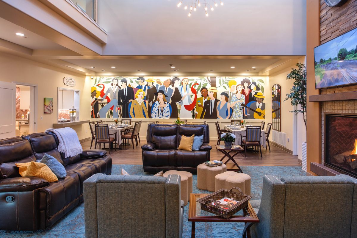 A modern lounge area featuring comfortable seating and vibrant artwork on the walls.