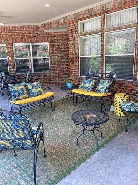 A cozy patio seating area with colorful cushions, metal furniture, and a rug.