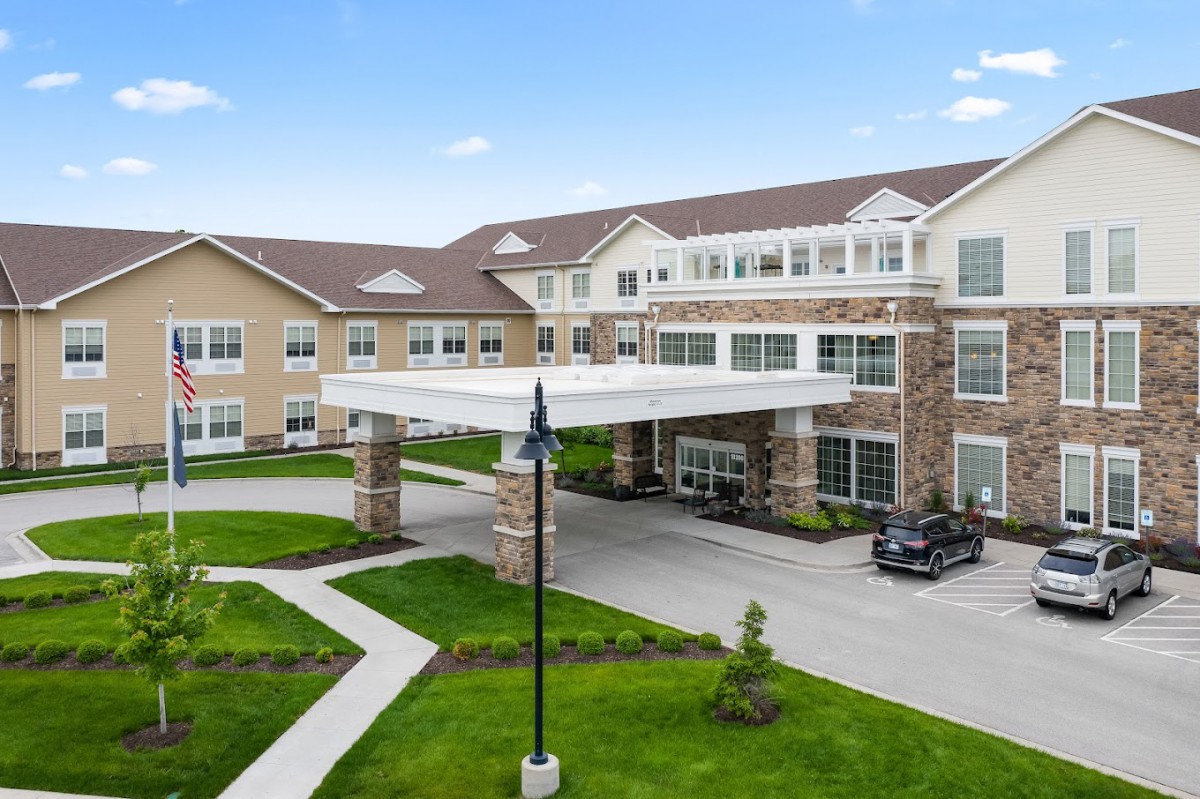 Exterior view of a modern residential building with landscaped surroundings and a driveway.