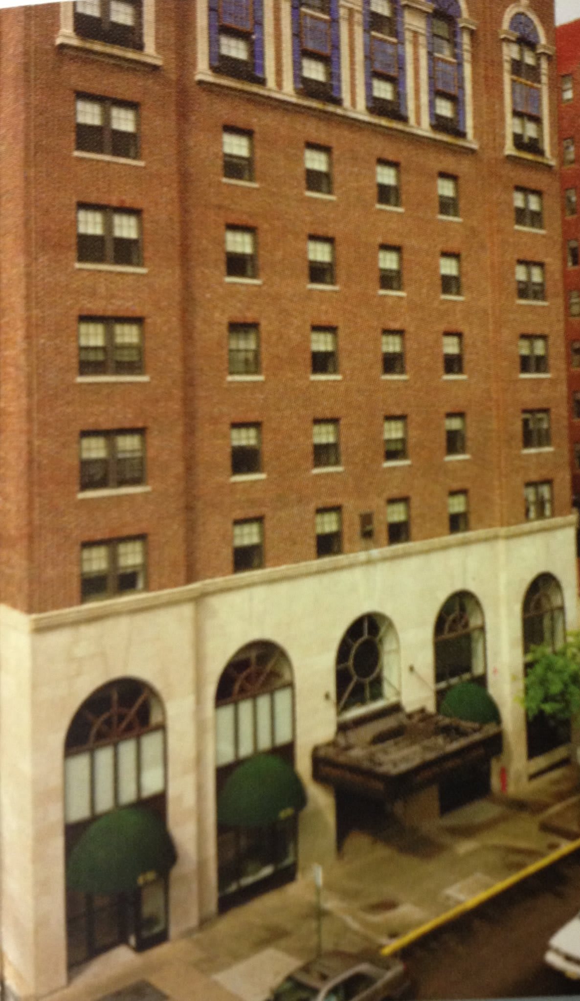 A view of a brick building with multiple windows and arched entrances.