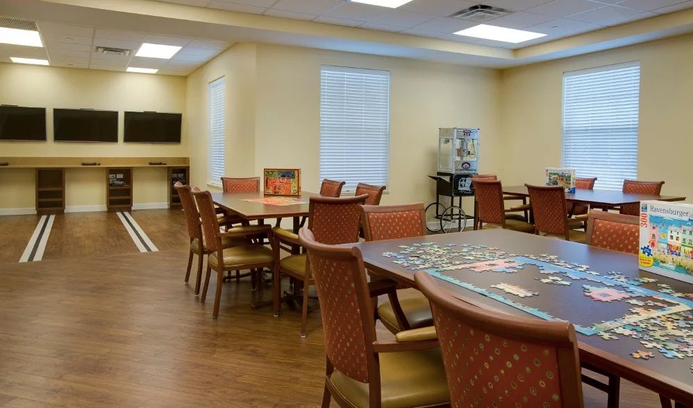 An empty room with tables and chairs, resembling a casino or game room.