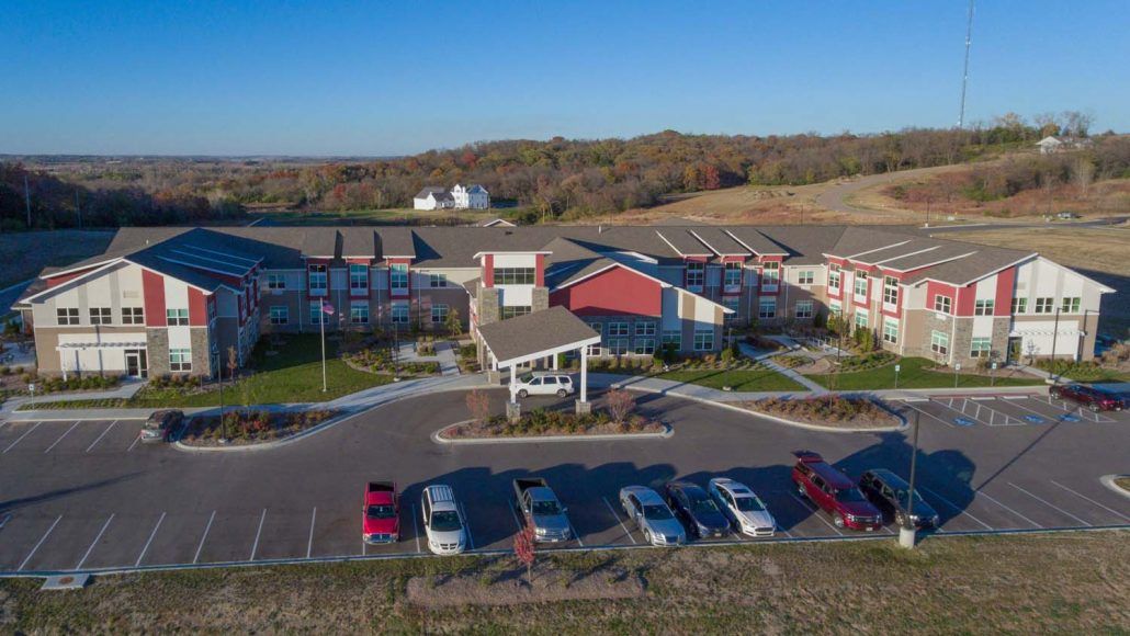 Aerial view of a large building with a parking lot in a rural setting.
