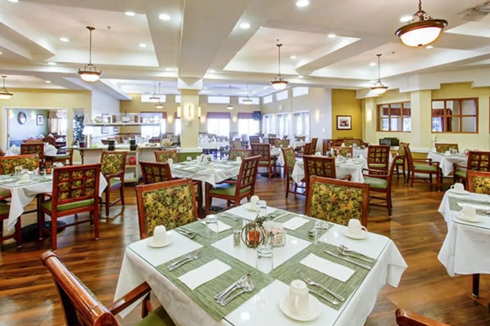 A spacious and elegantly decorated restaurant dining area with neatly arranged tables and chairs.