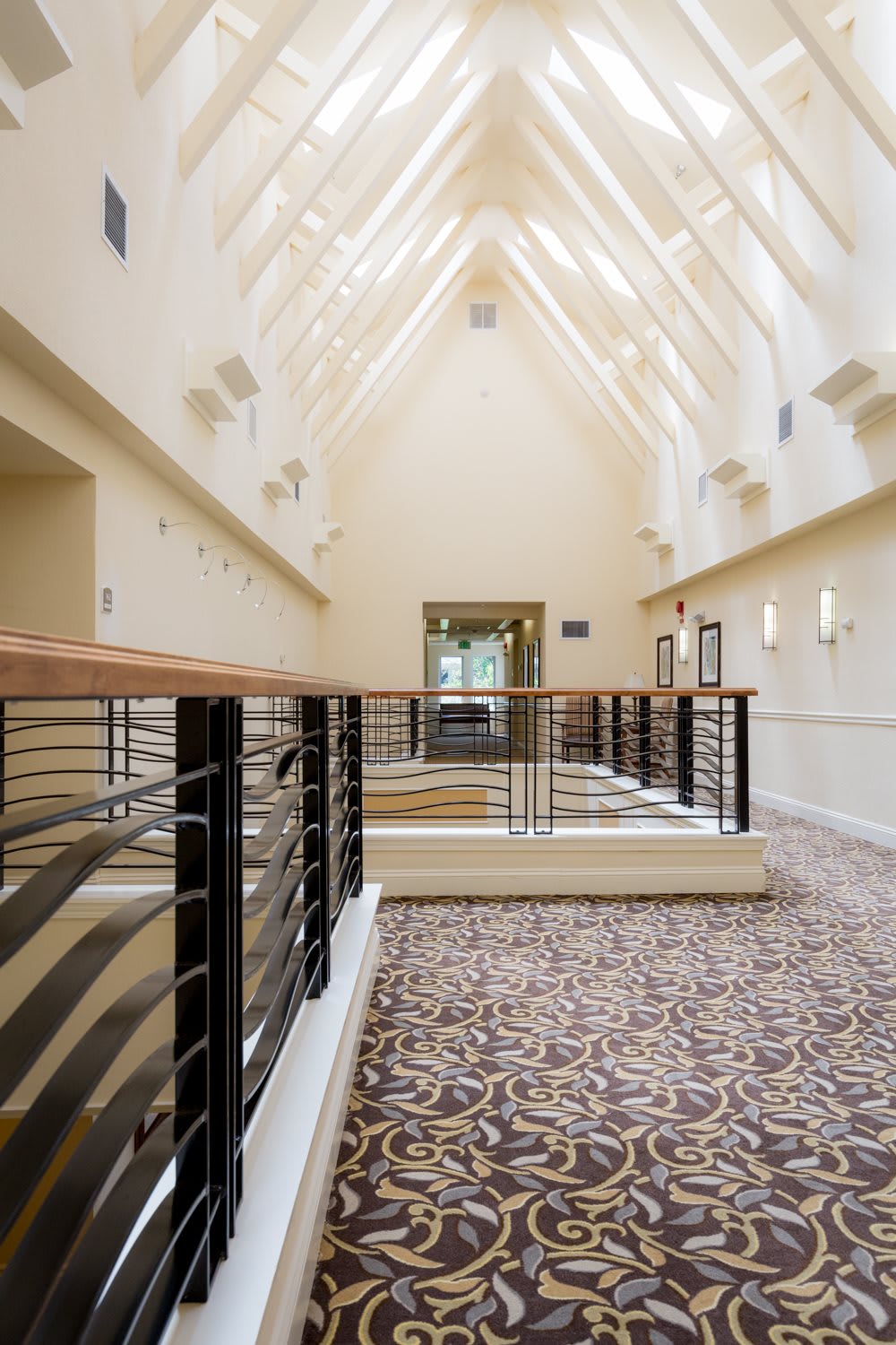 A modern hallway with skylights and sleek railings.