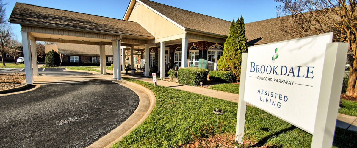 Front view of a building with a porch and landscaped entrance.