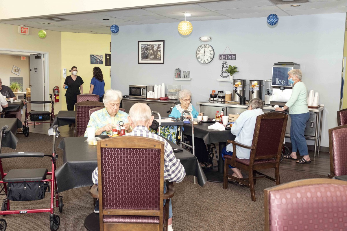 A group of elderly individuals enjoying a meal together in a communal dining space.