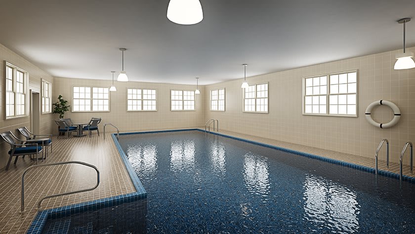 A serene indoor swimming pool with ample lighting and multiple windows.