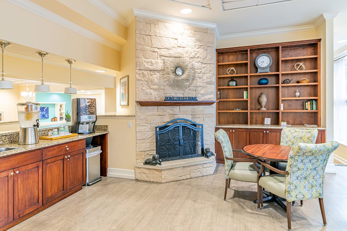 A cozy living room featuring a stone fireplace, built-in bookshelf, and a seating area.