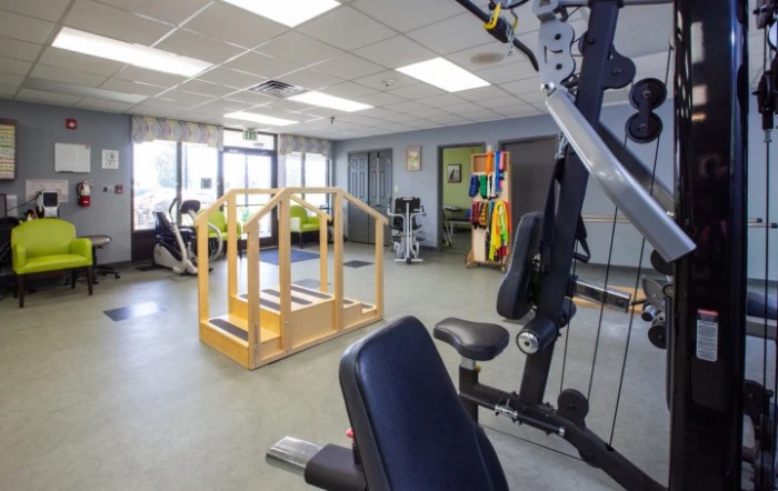 A well-equipped fitness and rehabilitation room with various exercise machines and therapy equipment.