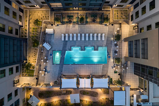 A serene aerial view of a luxury hotel swimming pool illuminated at night.